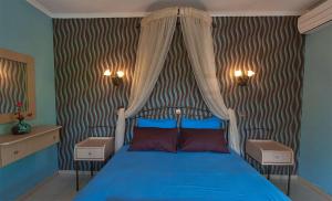 a bedroom with a blue bed with a canopy at Ktima Garas in Paralia Panteleimonos