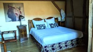 a bedroom with a bed with blue sheets and pillows at La Maison d'Artgile in Zimmersheim