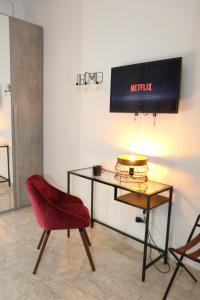 a red chair and a desk in a room at Bed and Breakfast Donna Maria in Bari