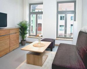 ein Wohnzimmer mit einem Sofa und einem Couchtisch in der Unterkunft Luv an der Nikolaikirche - ABC85 in Wismar