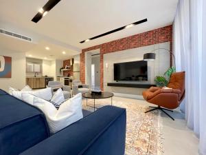 a living room with a blue couch and a fireplace at C Living - Executive - AQIQ in Riyadh
