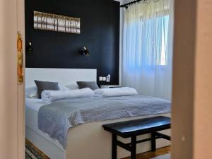 a bedroom with a white bed with a black wall at Cozy House Zivko with Balcony in Plitvička Jezera