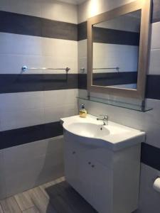 Christina Apartment في Ágios Konstantínos: حمام مع حوض أبيض ومرآة