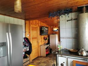 cocina con nevera y encimera en CASA CON QUINCHO en Ancud