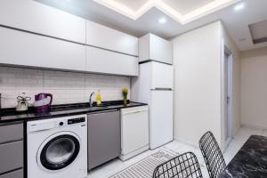 - une cuisine blanche avec un lave-linge et des chaises dans l'établissement Cozy Residence w Jacuzzi Balcony 5 min to Taksim, à Istanbul