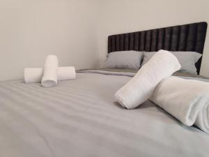 a bed with two rolled up towels on it at Maestro II Apartment in Larnaka