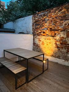 a table and bench sitting on a deck with a brick wall at NEU! Kleine Auszeit - ABC1 -nur Feriengäste! in Wismar
