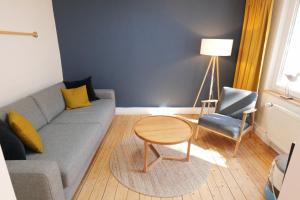 a living room with a couch and a table and a chair at NEU! Kleine Auszeit - ABC1 -nur Feriengäste! in Wismar