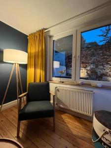 uma sala de estar com uma cadeira e uma janela em NEU! Ferienhaus Kleine Auszeit - Nur für Feriengäste - ABC1 em Wismar