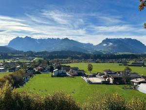 a small town in a field with mountains in the background at Apartment Sonnenwinkl in Kössen