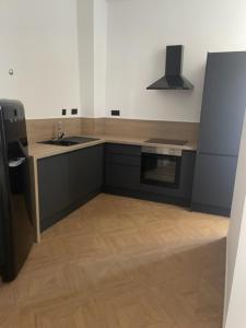 a kitchen with a sink and a refrigerator at Le Manoir du Monde in Lieu-Saint-Amand