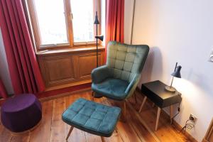 - un salon avec un fauteuil et un pouf dans l'établissement Neue Wasserkunst - Premium Gruppenferienwohnung - ABC354, à Wismar