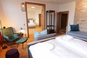 Cette chambre comprend un lit, une chaise et un miroir. dans l'établissement Neue Wasserkunst - Premium Gruppenferienwohnung - ABC354, à Wismar