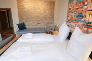 deux lits dans une chambre avec un mur de briques dans l'établissement Neue Wasserkunst - Premium Gruppenferienwohnung - ABC354, à Wismar