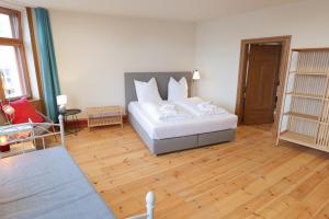 une chambre avec un lit blanc et un parquet dans l'établissement Neue Wasserkunst - Premium Gruppenferienwohnung - ABC354, à Wismar 12 autres photos