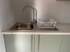 a kitchen sink with a basket on the counter at Rollers Rest Guesthouse in Boksburg