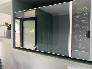 a microwave oven on a wall with a window at Rollers Rest Guesthouse in Boksburg