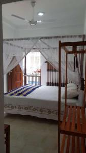 a bedroom with a canopy bed and a chair at Blue sky villa in Mirissa