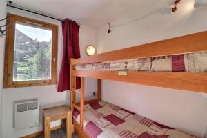 zwei Etagenbetten in einem Zimmer mit Fenster in der Unterkunft Cimes 2 B17 in Méribel