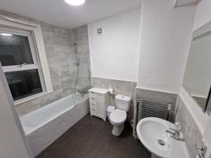 a bathroom with a toilet and a sink and a bath tub at Liverpool city 5 bed house sleeps 12 in Liverpool