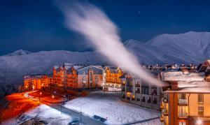 a view of a building in the snow at night at New Gudauri Sweet Apartment With Fireplace and view The Gondola Lift in Gudauri