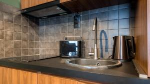 a kitchen counter with a sink and a coffee maker at New Gudauri Sweet Apartment With Fireplace and view The Gondola Lift in Gudauri