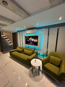 a living room with two green couches and a tv at gazelle suites in Istanbul