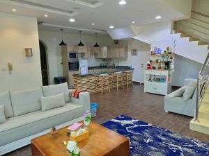 a living room with a couch and a kitchen at شاليه لارا in Rayyis