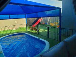 a swimming pool with a slide and a playground at شاليه لارا in Rayyis