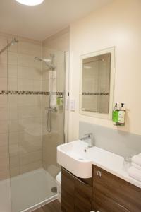 a white bathroom with a sink and a shower at The Black Horse Inn in Maidstone