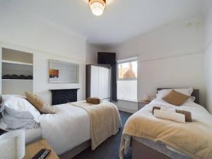 a large bedroom with two beds and a fireplace at Cozy Hull House near City Centre - Walkable to the Deep in Hull