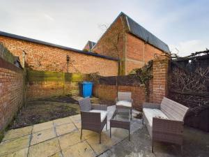 a patio with chairs and a bench and a brick wall at Cozy Hull House near City Centre - Walkable to the Deep in Hull