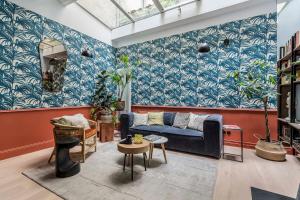 a living room with blue and white wallpaper and a couch at Jungle-Art - duplex très calme et cosy in Lyon