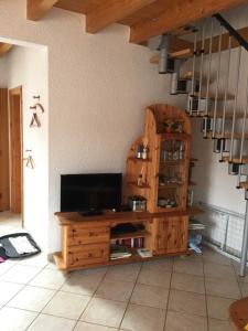 a living room with a television on a wooden cabinet at Ferienhaus Walther in Erbach