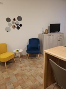 een kamer met 2 stoelen, een tafel en een tv bij Piccolo Loft in Foligno