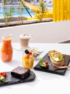 a table with two plates of food and a cup of coffee at Sholeo Lodges Los Gigantes in Puerto de Santiago +69 photos
