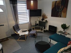 ein Wohnzimmer mit einem Sofa, Stühlen und einem Tisch in der Unterkunft Beaufort comfi stays in Gainsborough