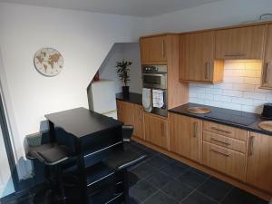 a kitchen with wooden cabinets and a black counter top at Beaufort comfi stays in Gainsborough