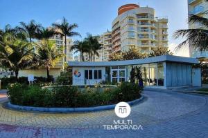 a building in front of a building with palm trees at Vista inesquecível para o mar homeclub BetoCarrero in Penha