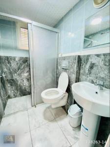 y baño con aseo, lavabo y ducha. en Deniz Pansiyon, en Alanya