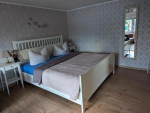 a bedroom with a large bed and a mirror at Casa Hibiscus 2 in Putbus