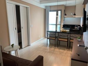 a living room with a kitchen and a dining room table at Ocean Flat Premium com vista para o mar in Vila Velha