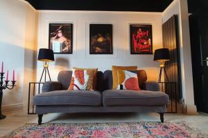 a blue couch in a living room with pictures on the wall at Designer 4-Bed Home in the Heart of Belfast in Belfast