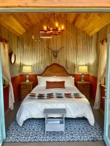 sypialnia z dużym łóżkiem i żyrandolem w obiekcie Hideout Ridge 