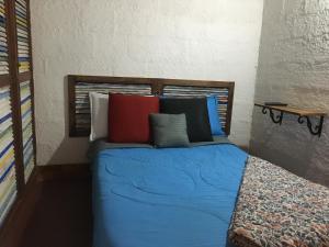 a bedroom with a blue bed with colorful pillows at Casa típica de la Región del Café in Calarcá