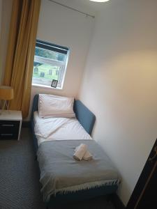 ein kleines Bett in einem kleinen Zimmer mit Fenster in der Unterkunft Beaufort comfi stays in Gainsborough