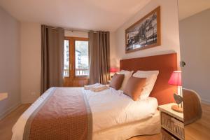 a bedroom with a large bed and a window at SavoieLac - Appartement Primeveres in La Clusaz