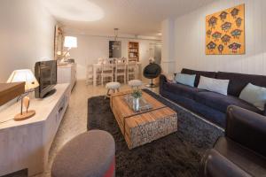 a living room with a couch and a table at SavoieLac - Appartement Primeveres in La Clusaz