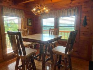 a dining room with a wooden table and chairs at Yogi's Den: Breathtaking Views! 3 min to Dollywood, on 1 acre! in Sevierville