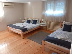 1 dormitorio con 2 camas y ventana en Apartman Talija, en Arandjelovac
